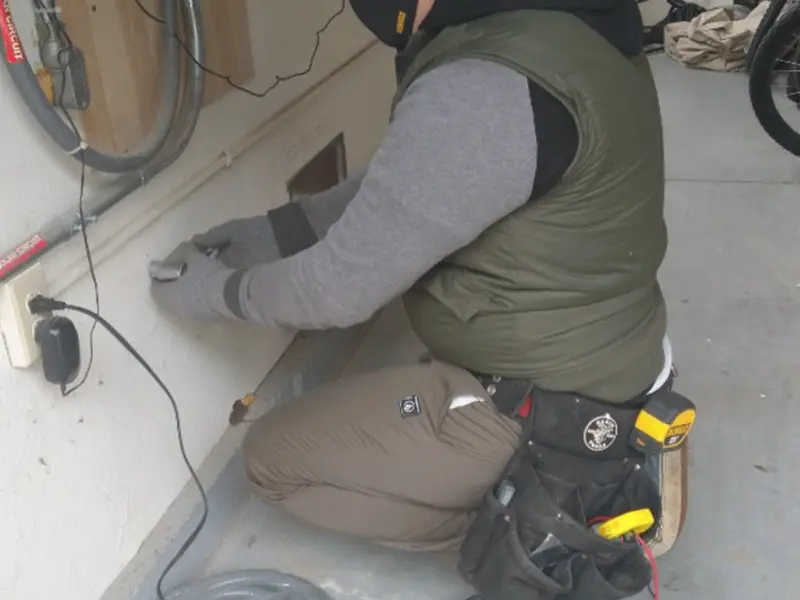 Electrician performing outlet wiring in a Van Buren garage